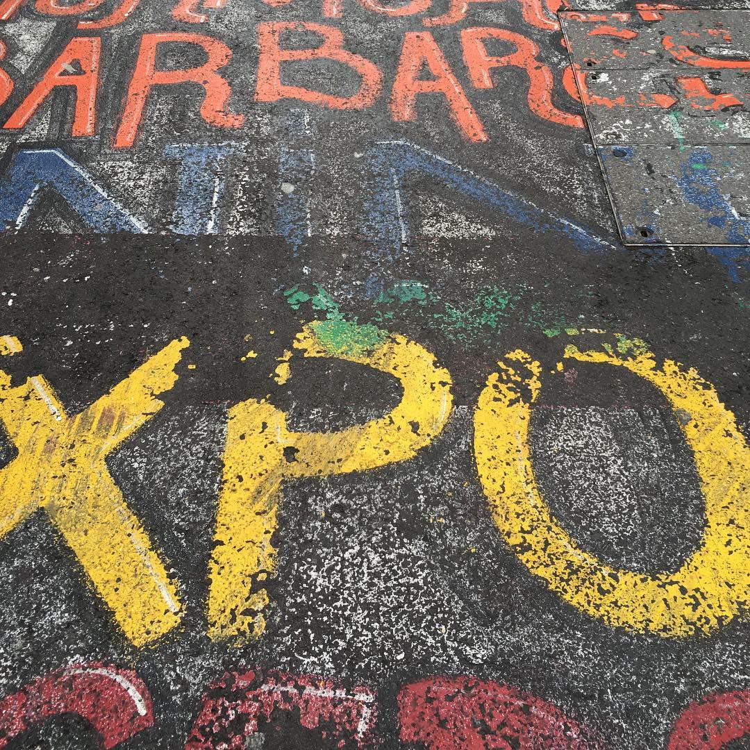 Painted letters on the ground, in red, blue and yellow