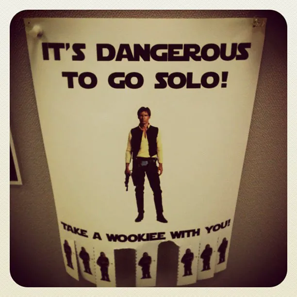 A Han Solo poster on a door: 'It's dangerous to go Solo! Take a Wookiee with you'