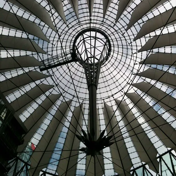 Looking up into a tent-like glass and steel roof