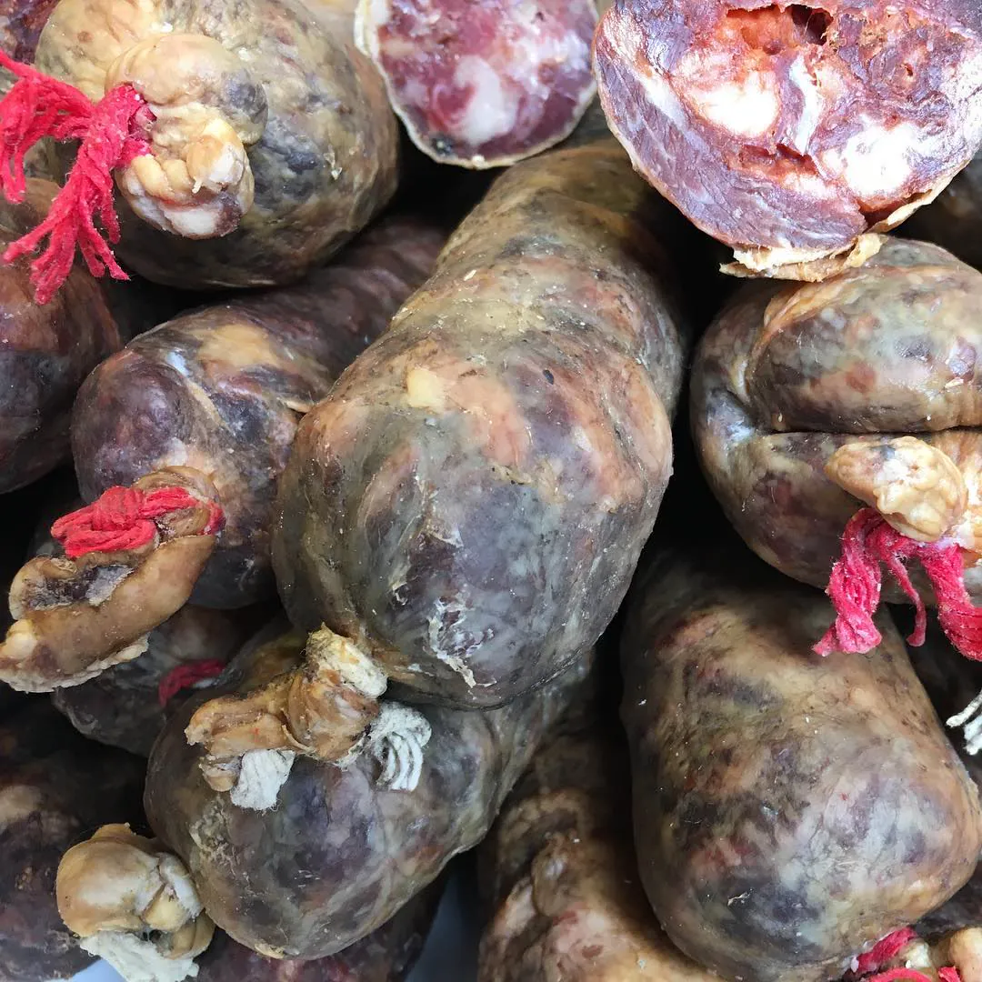 A pile of dark cured chorizos tied with red string