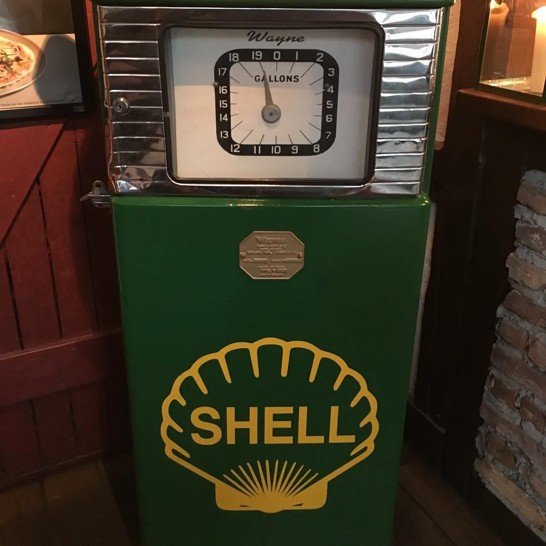 A vintage green Shell petrol pump with a Wayne gallons dial