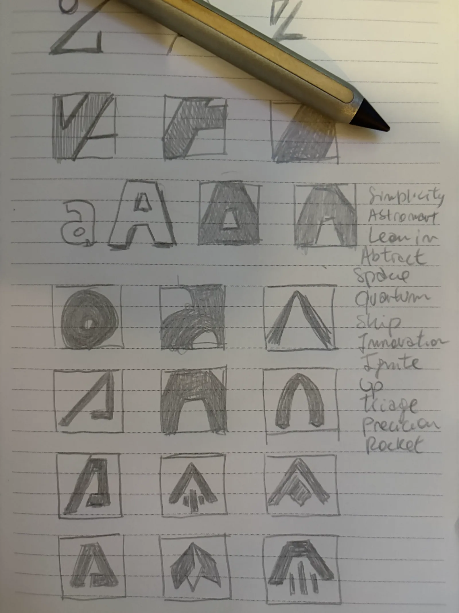 A notebook page of pencil logo sketches built from the letter A, with a list of words beside them